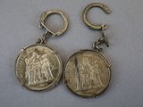 two silver coin earrings with a small silver coin on them
