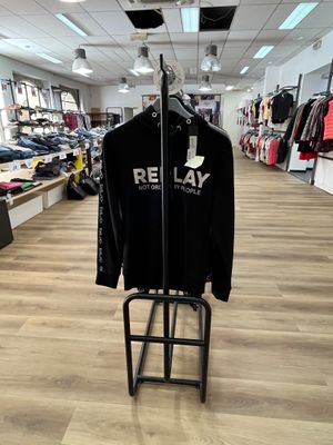 un t-shirt noir suspendu à un portant dans un magasin de vêtements