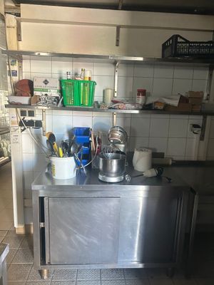 un plan de travail en acier inoxydable sur lequel sont posés des casseroles et des poêles