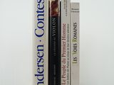 three books sitting on top of each other on a white surface