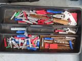 many different tools in a plastic container on the table