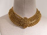 a close up of a gold necklace on a mannequin mannequin