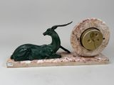 a statue of a deer and a clock on a marble base