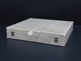 a gray box with a handle on a black table