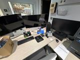 une photo d'un bureau d'ordinateur avec trois écrans et un ordinateur portable