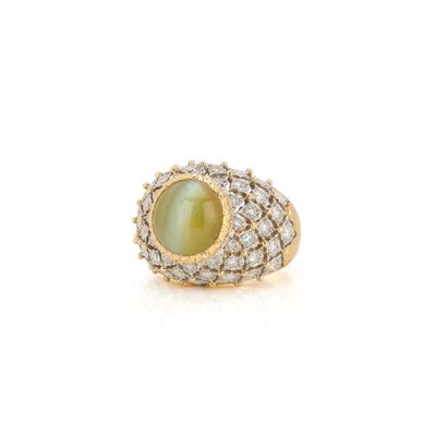 gros plan d'une bague avec une pierre verte entourée de diamants