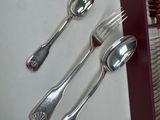 silverware in a wooden box with spoons and spoon rest on a table