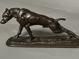 bronze statue of a dog on a base with a name plate