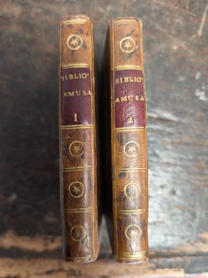 une paire de livres anciens reliés en cuir posés sur une table en bois