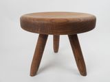a small wooden stool with three legs on a white background