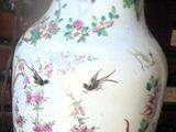 a vase with a bird design on it sitting on a table