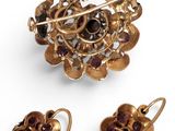 an image of a gold brooch and earring set with garnetts