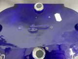 a blue clock on a table with a pair of scissors on it