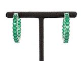 a close up of a pair of green earrings on a stand