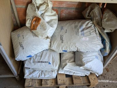une pile de sacs de ciment posée sur une palette