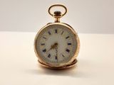 une image d'une montre de poche en or avec des chiffres romains sur le cadran