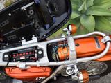 a close up of an orange motorcycle with a mirror on it