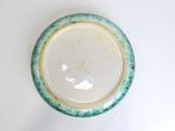 underside view of a green and white bowl with a gold rim
