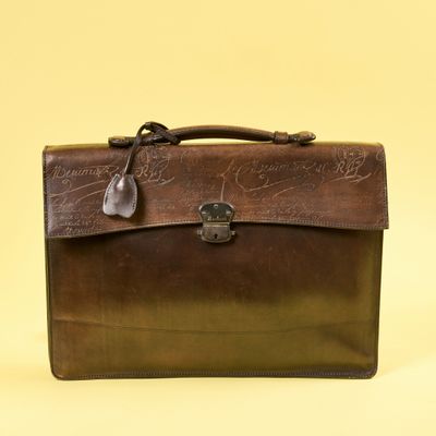 une mallette en cuir marron portant une inscription sur fond jaune