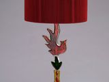 lamp with a red shade and a bird on the base