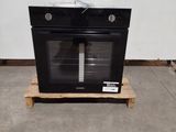 a black oven sitting on a pallet in a room