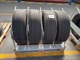 three tires are stacked on a pallet in a warehouse