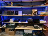 a room with a shelf full of clothes and other items
