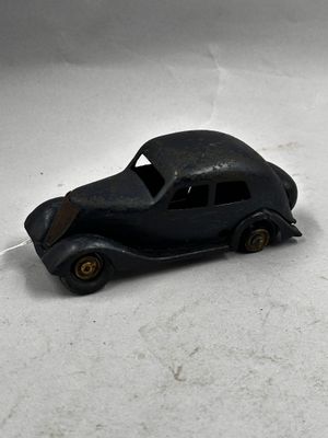 une petite voiture noire posée sur une surface blanche