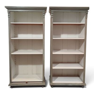 pair of white painted bookshelves with open shelves on each side