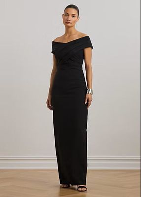La femme en robe noire prend la pose devant l'appareil photo.