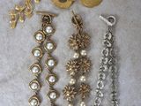 trois paires de bijoux en or et perles posés sur un fond blanc