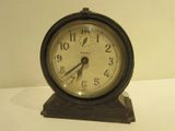 a small clock sitting on top of a white table
