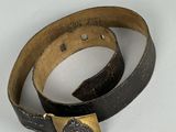 leather belt with a metal buckle on a white surface