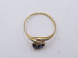a close up of a gold ring with blue stones on it