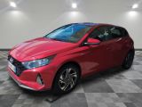 une voiture rouge garée dans un garage au sol en damier