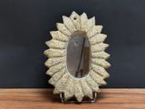 a small mirror sitting on top of a wooden table