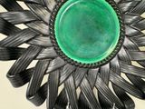 a green plate sitting on top of a metal flower