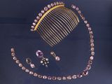 un peigne, un collier, des boucles d'oreilles et une bague posés sur une table
