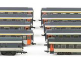 several model trains are lined up in rows on a white surface