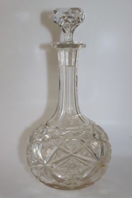 une carafe en verre posée sur une surface blanche