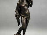 a bronze statue of a man holding a bird on top of a rock