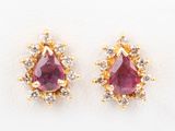 a pair of ruby and diamond earrings on a white background