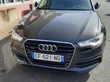 a black audi is parked in front of a building