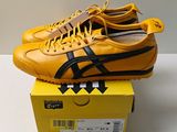 des baskets Onitsuka jaunes et noires posées sur une boîte jaune, elle-même posée sur une table blanche