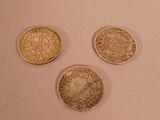 three different types of coins sitting on a white surface