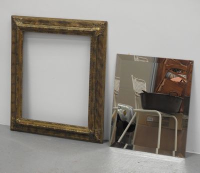 une photo représentant un miroir et un cadre posé par terre