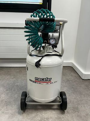 an air compressor sitting on top of a cart with a hose attached to it