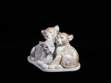 une figurine représentant un chat et deux chatons posée sur une assiette