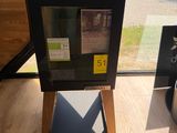 une boîte noire posée sur un socle en bois devant une fenêtre