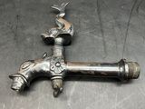 a metal faucet that has a bird on it